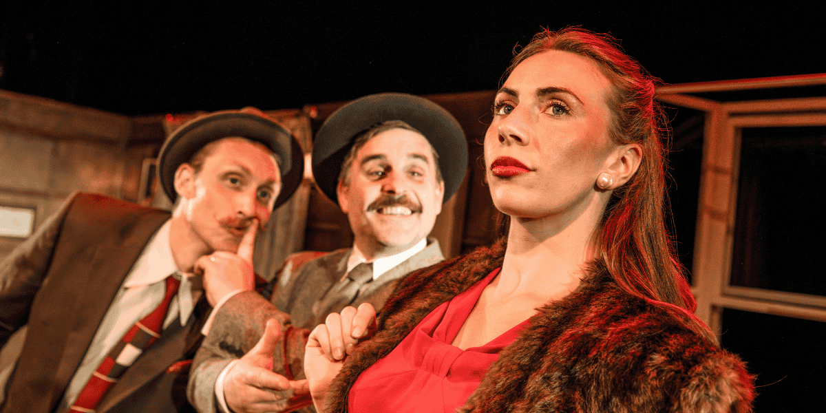 Show: A Shoddy Detective & The Art of Deception Image: Two detectives in background, one woman in red in the foreground