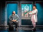 An actor sitting on a ledge talking to another actor standing up in A Strange Loop