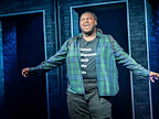 An actor singing with his arms out wide in A Strange Loop