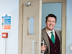 Man in suit and tie opening in a door and smiling