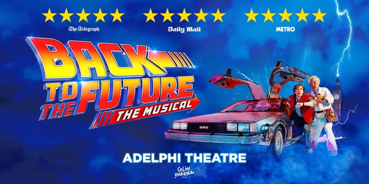 TEXT: Back to the Future the Musical. Adelphi theatre. Doc and Marty stand next to the Delorean time machine which has both doors open. Doc looks at a stop watch, Marty at his wrist watch. The city clock tower is in the background.