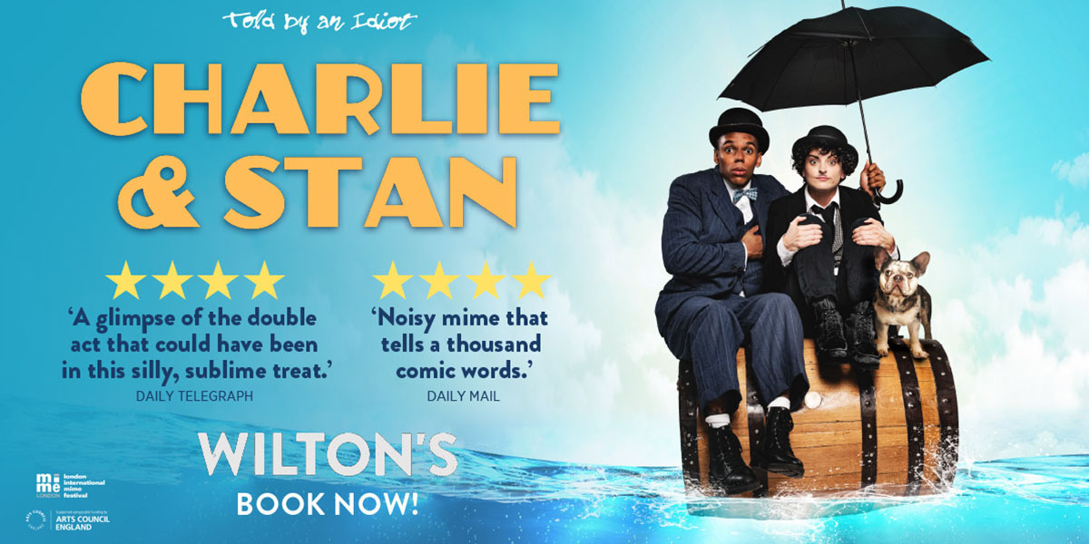 Text: Told by an idiot. Charlie and Stan, 4 star Daily Telegprah 'A Glimpse of the double act that could have been in this silly, sublime treat', Daily Mail 4 star 'Noisy mime that tells a thousand comic words' Wilton's, book now!  Image: Danielle Bird as Charlie Chaplin, alongside Jerone March Reid as Stan Laurel, dressed in suits and sat on a barrel in the ocean, with an umbrella. 