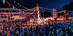 Photo by Danny Kaan - Long shot of a funfair with a crowd surrounding a ride