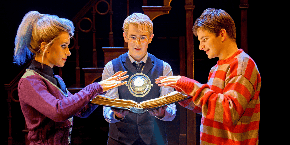 Delphi, Scorpius and Albus stand around an open book, as the timeturner hovers above it.