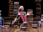 Danyah Miller sat on a pile of books surrounded by a pile of books.