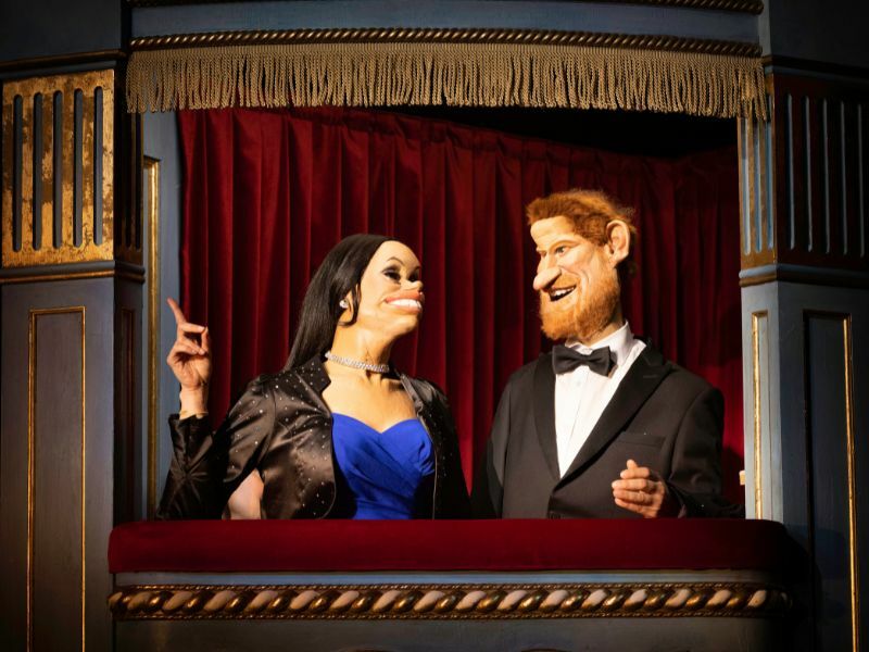 Spitting Image Puppets of Meghan Markle and Prince Harry sat in a box at the theatre
