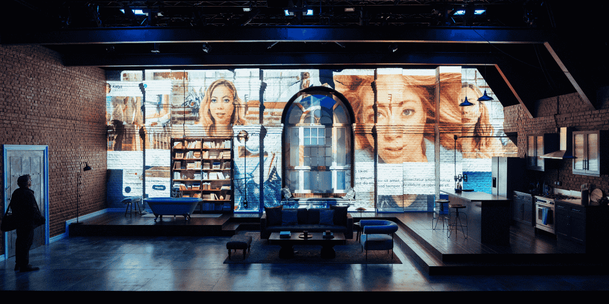 Show: Interview at Riverside Studios Image: A studio apartment with walls illuminated by projections of multiple social media profiles of the same person