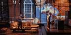 Show: Interview at Riverside Studios Image: Two people standing in the living room as one films the other