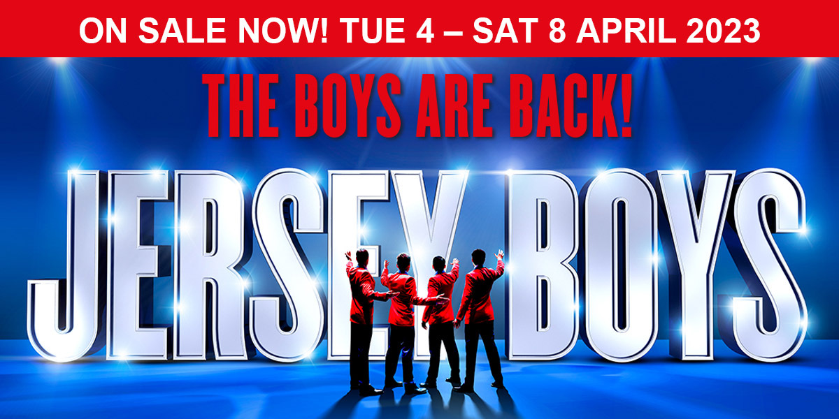 TEXT: On Sale Now! Tue 4- Sat 8 April 2023 The Boys are Back! Jersey Boys. IMAGE: The Jersey Boys in their iconic red jackets, stand in a line pointing to the large "Jersey Boys" sign .