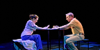 Man and woman sitting down with their hands on the table in Mary Page Marlowe