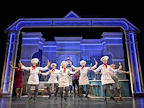 Chefs dancing holding wooden spoons.