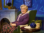 Msr Doubtfire sat in a chair holding a tablet