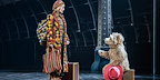 Paddington greets Mrs Brown with his suitcase at the London station scene in the musical.