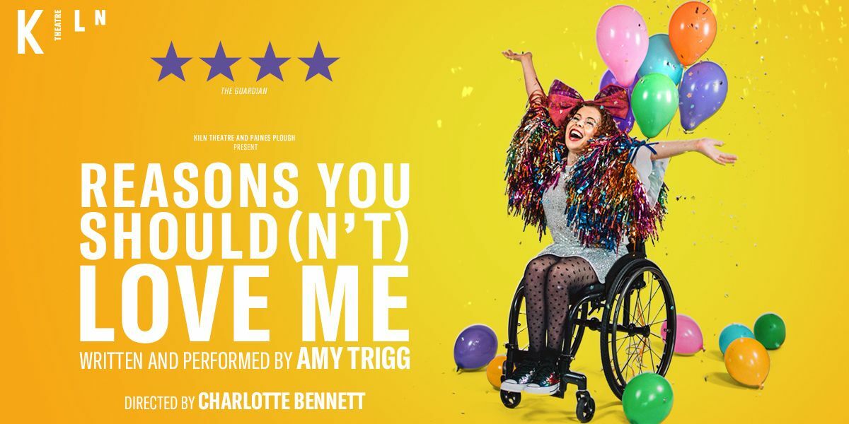 Text: Kiln Theatre. 'Enormously Entertaining' The Guardian. Kiln Theate and Plaines Plough present Reasons You Should(n't) Love Me. Written and performed by Amy Trigg. Directed by Charlotte Bennett. | Image: A person sits in a wheelchair which has balloons tied to it and surrounding it. They have their arms raised in joy. They are wearing a huge bow on their head and a very rainbow shiny jacket.