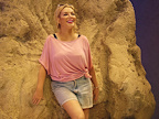 Sheridan Smith in Shirley Valentine - leaning against rock on beach wearing tshirt and demin shorts