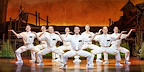 The ensemble of missionaries kneel in unison during a comic performance from the Book of Mormon London cast.