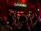 Crowded cocktail bar with a neon Cocktail sign.