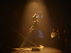 Person sat on a girder under a spotlight