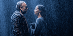 Man and woman soaked in the rain looking at each from The Lady From the Sea.