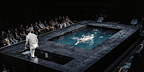 Man swimming in a pool on stage from The Lady From the Sea