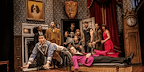 Group of people looking shocked and man falling in The Play That Goes Wrong
