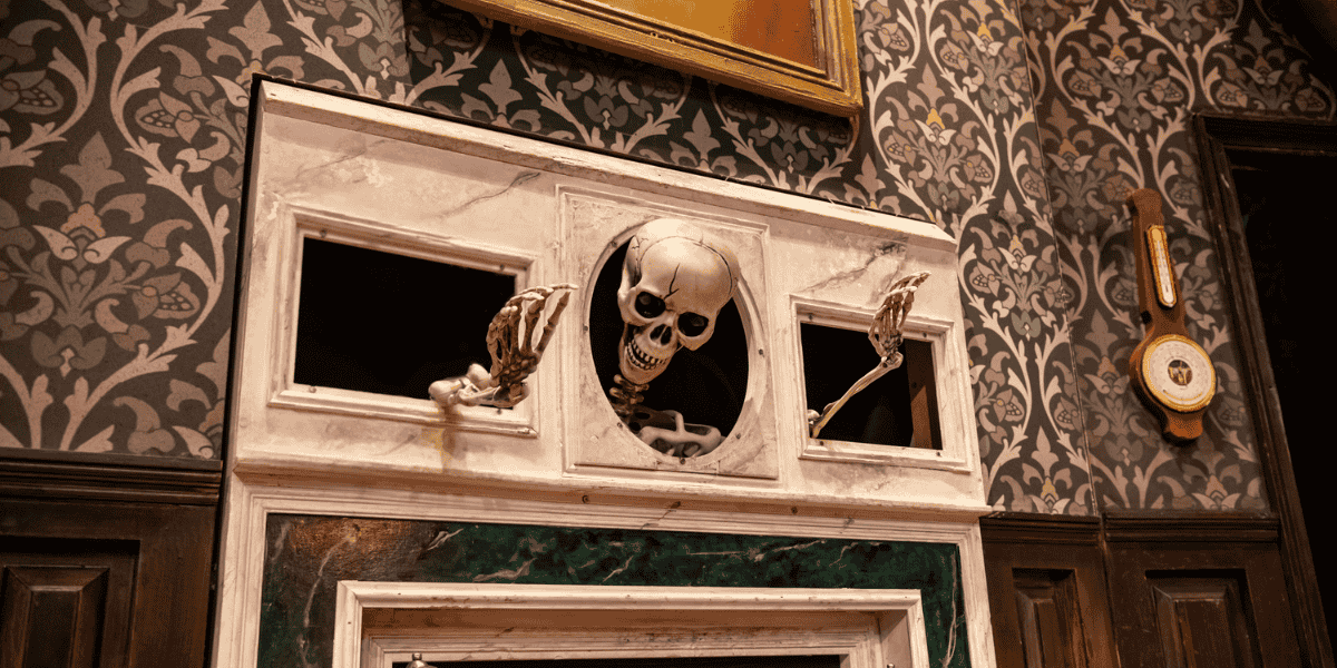Skeleton's arms and head stuck in a wall in The Play That Goes Wrong