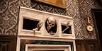 Skeleton's arms and head stuck in a wall in The Play That Goes Wrong