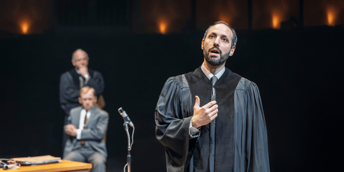 Man in cloak speaking in a microphone from The Spy Who Came In From The Cold