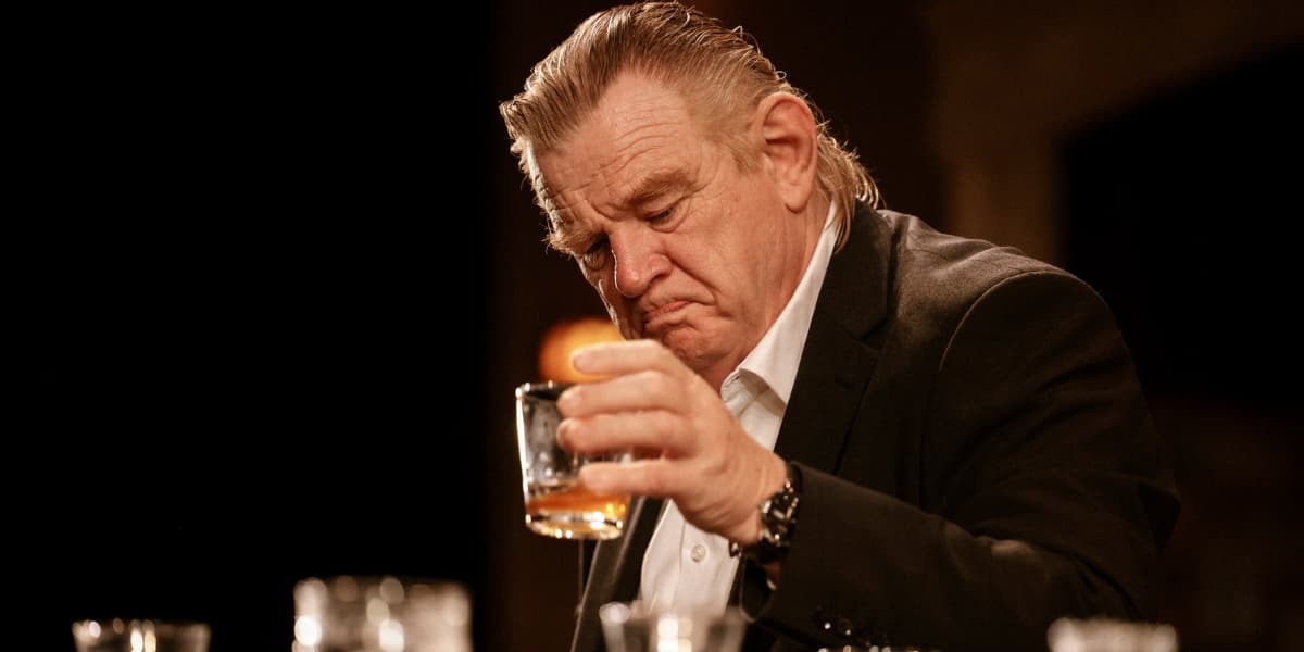 Brendan Gleeson has a glass of whiskey in The Weir