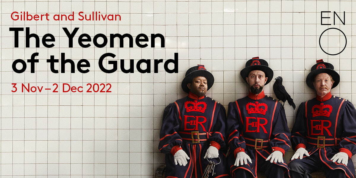 ENO Gilbert and Sullivan The Yeoman of the Guard tickets 3 November - 2 December 2022. Against white subway tiles, 3 men in Guard uniforms, hats and gloves sit on a bench. The man in the middle has a raven perched on his shoulder.