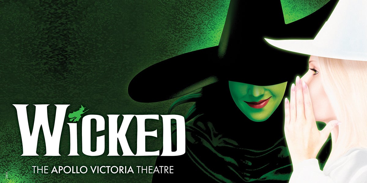 Blonde Hair Witch, whispering in the ear of a green faced witch. Wicked London 