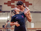 Two dancers share an intimate moment while rehearsing in a studio. The atmosphere is filled with passion and focus.