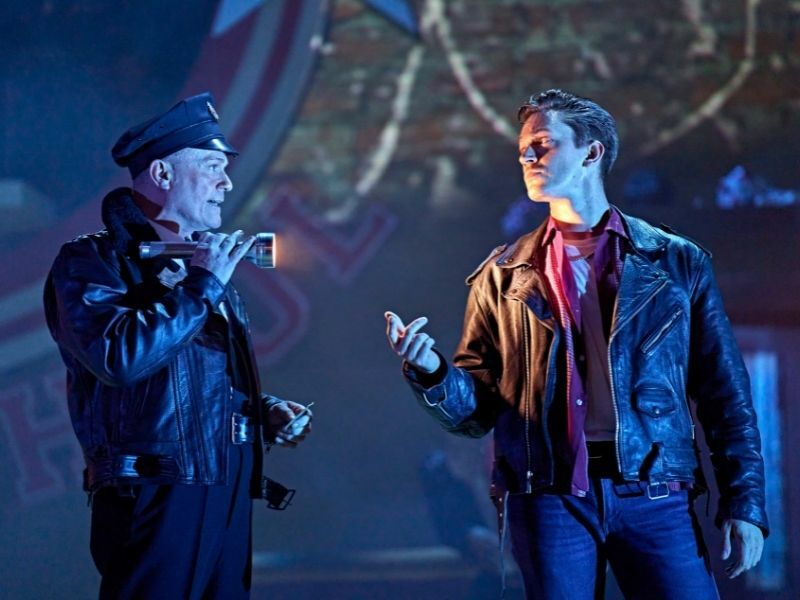 Production image of [LtoR] Darren Bennett as Officer Mailie & Dan Partridge as Danny in GREASE in London | credit Manuel Harlan