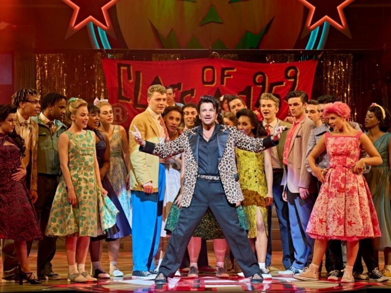 Production image of Peter Andre as Vince Fontaine (centre) with the company in GREASE in London | credit Manuel Harlan