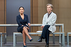 Preeya Kalidas (Flint) and Juliet Stevenson (Ruth Wolff) - The Doctor sitting together on a bench looking into the distance. The character Ruth is dressed as a doctor and the character flint is dressed in smart business clothing.