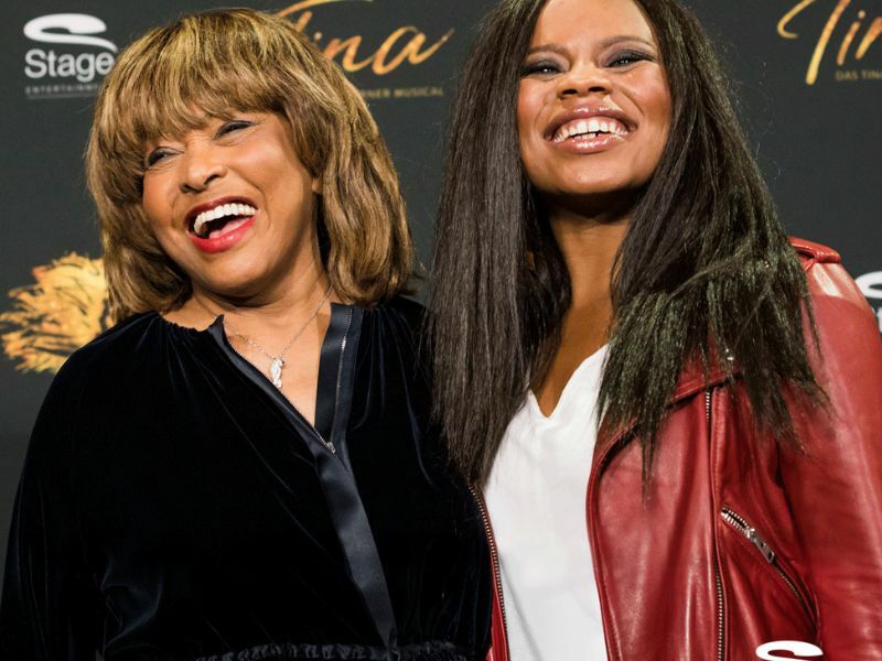 Image: Kristina Love and Tina Turner, Kristina can be seen smiling wearing a red leather jacket. Tina Turner can be seen wearing a black jacket and smiling.