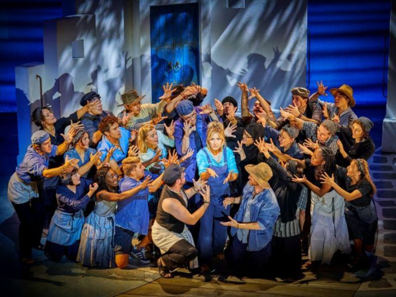 Centre Mazz Murray as Donna with the cast of MAMMA MIA!, credit Brinkhoff-Moegenburg