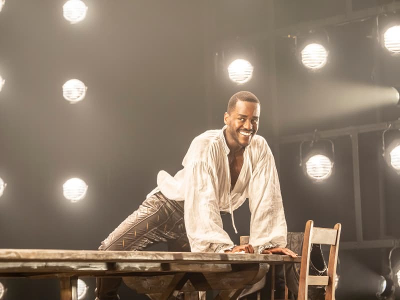 Ncuti Gatwa climbs on a table in Born With Teeth