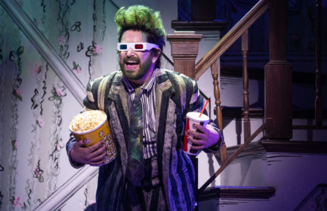 Beetlejuice wearing anaglyph glasses, and holding a large movie popcorn and drink